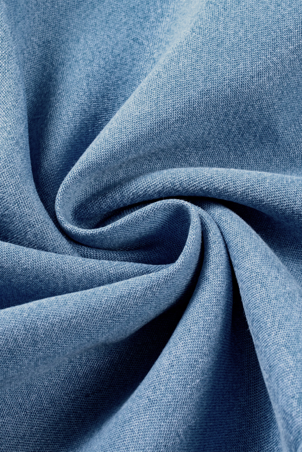 Close-up swirl of lightweight chambray denim fabric showing soft texture and weave at Tela Designs Store