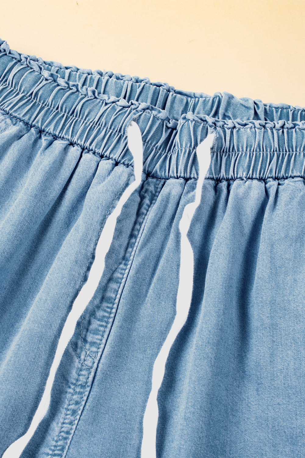 Close-up of ruched waistband with drawstring eyelets on wide-leg chambray pants at Tela Designs Store
