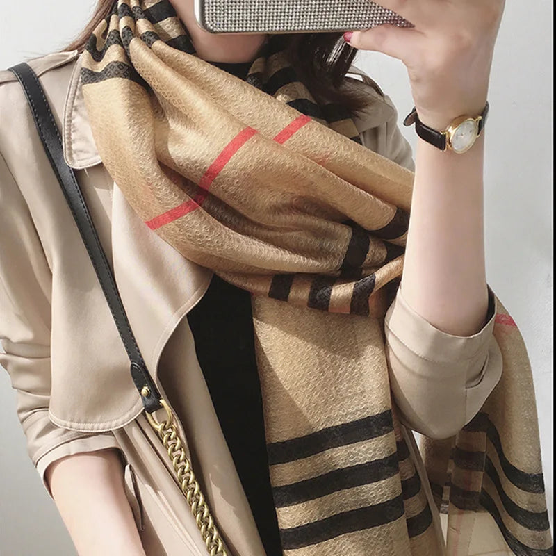Unapologetic Luxury Silk Shawl Scarf styled and worn by a female model shown wearing it from the neck to the midsection as she hides her face with a phone taking a selfie. Scarf by Tela Designs Store.