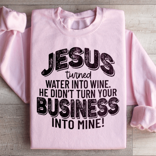 Light pink Christian sweatshirt folded with bold statement, "Jesus turning water into wine He didn't turn your business into mine" a message on respecting boundaries