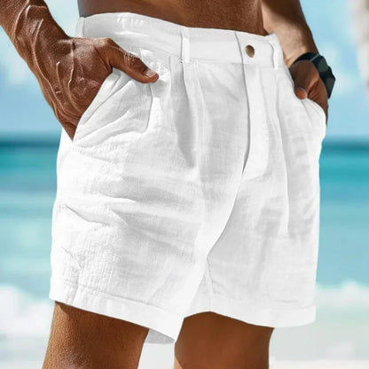 Close-up of white linen-cotton blend men's shorts with button fly and pleated design, ideal for warm weather/beachwear.