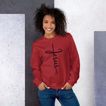 Smiling African American woman with wavy afro wearing red JESUS script sweatshirt and jeans.